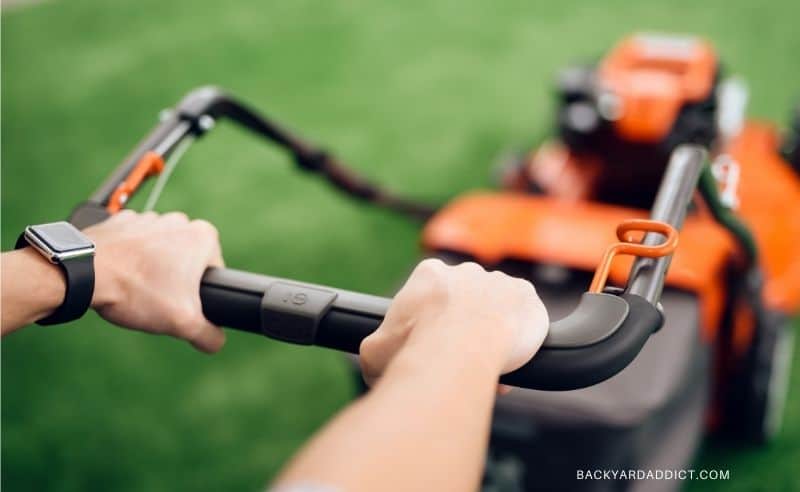hands pushing mower