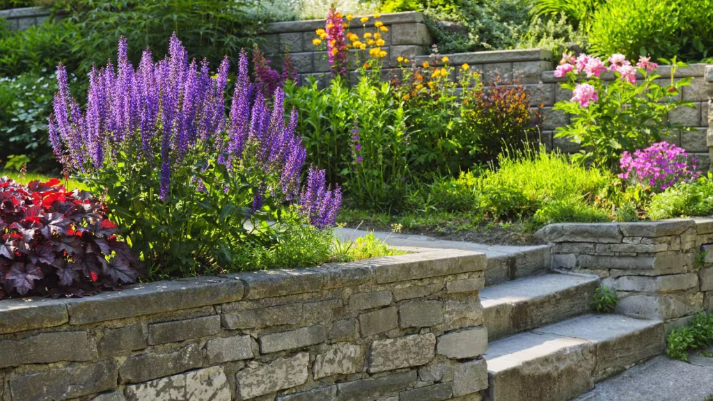 stone steps going up between two retaining walls with flower beds