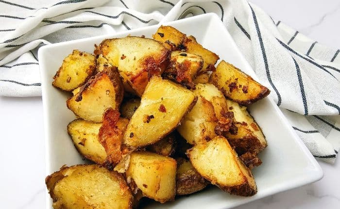 Roasted potatoes served in a white square dish