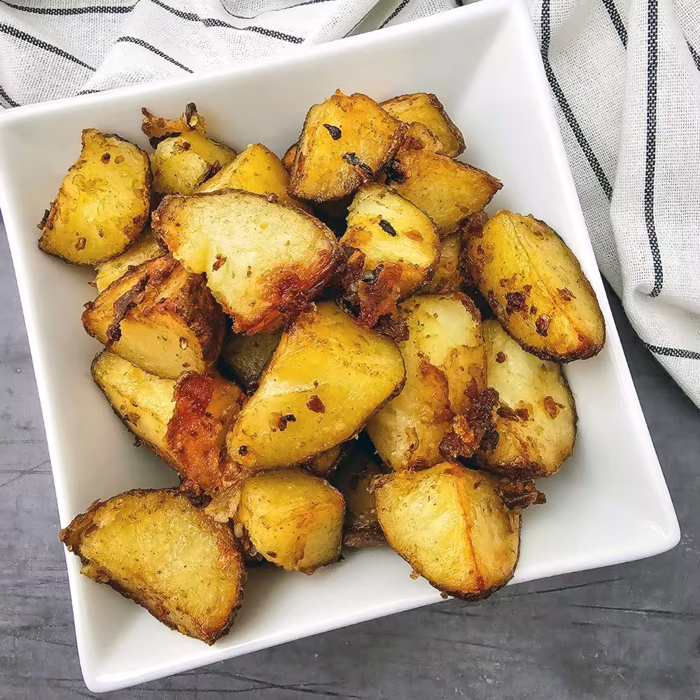 Roasted potatoes served in a white square dish